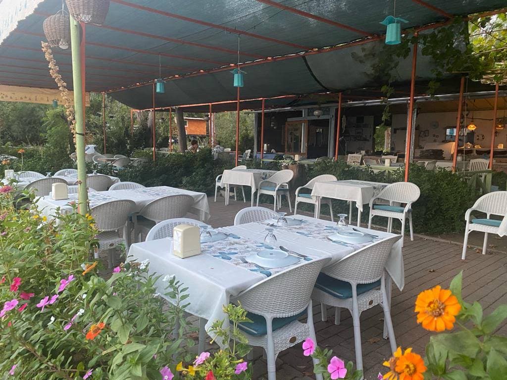 Adrasan sahilindeki Kaptan Otel Restoran bahçesinde servise hazırlanmış masalar